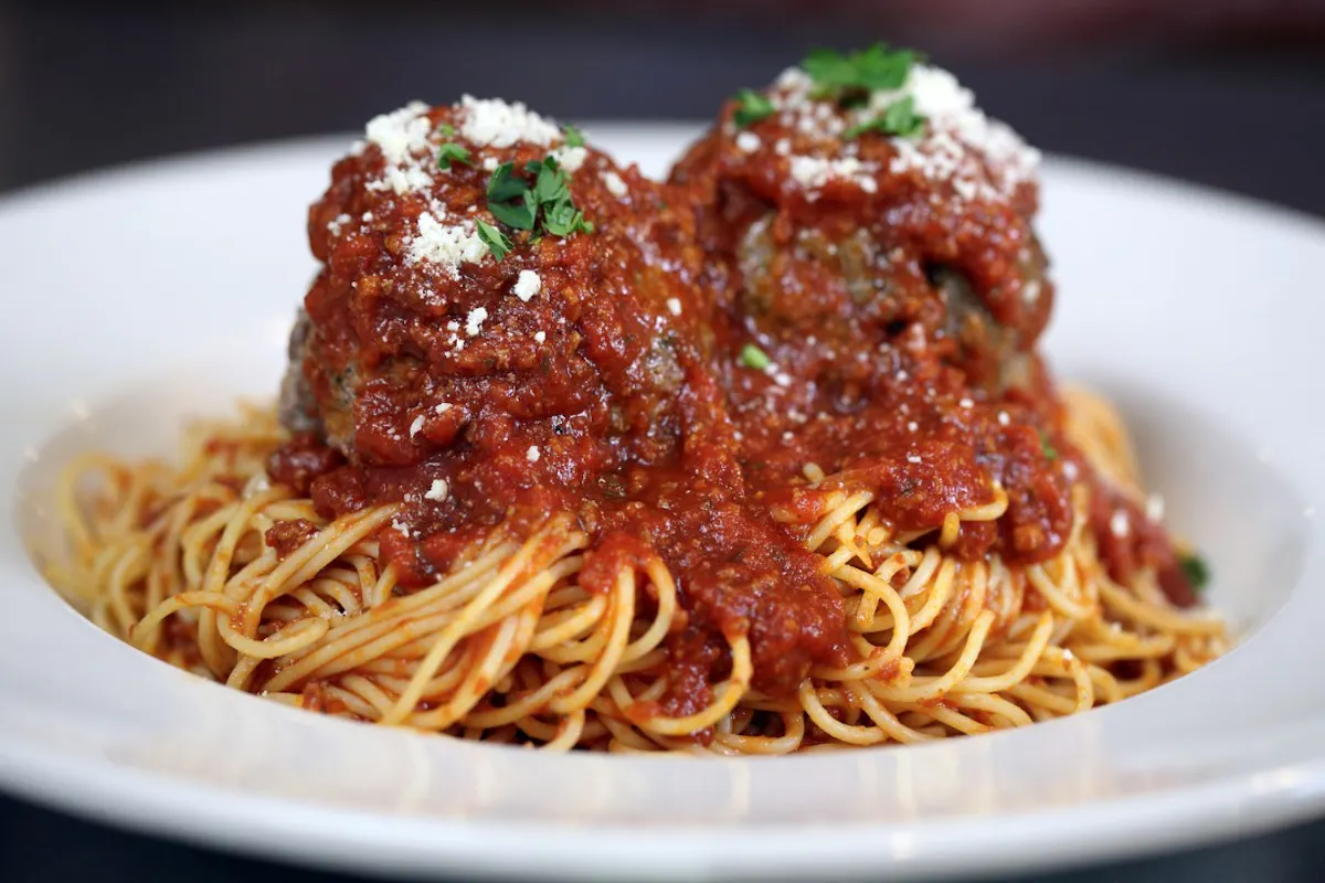 a closeup of spaghetti topped with tomato sauce